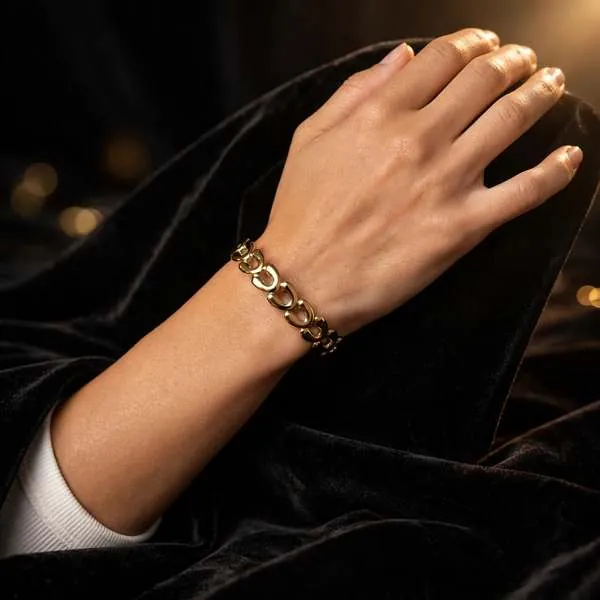 Textured gold link bracelet styled against dark velvet